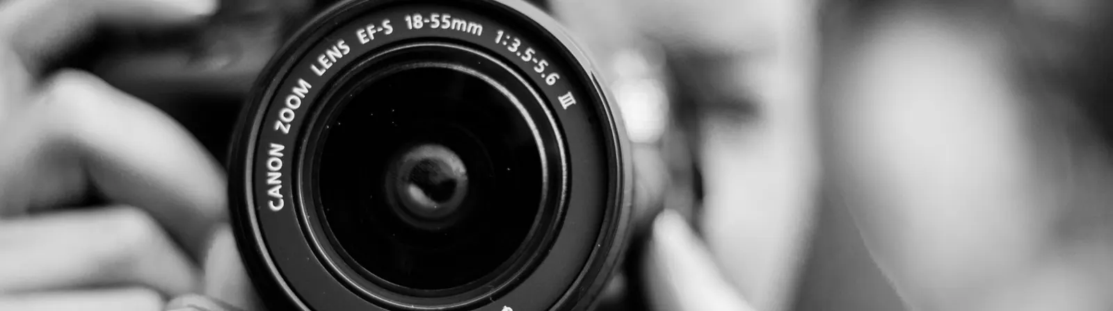 Gros plan sur l’objectif d’un appareil photo, en noir et blanc